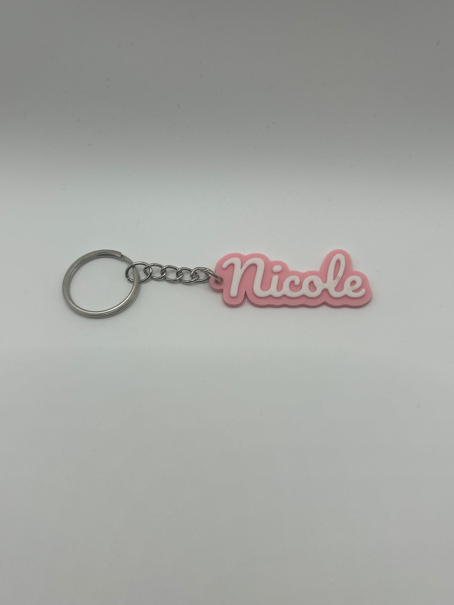 Personalized name keychain from NiccieNacks in various colors, featuring custom text on a stylish keychain accessory.