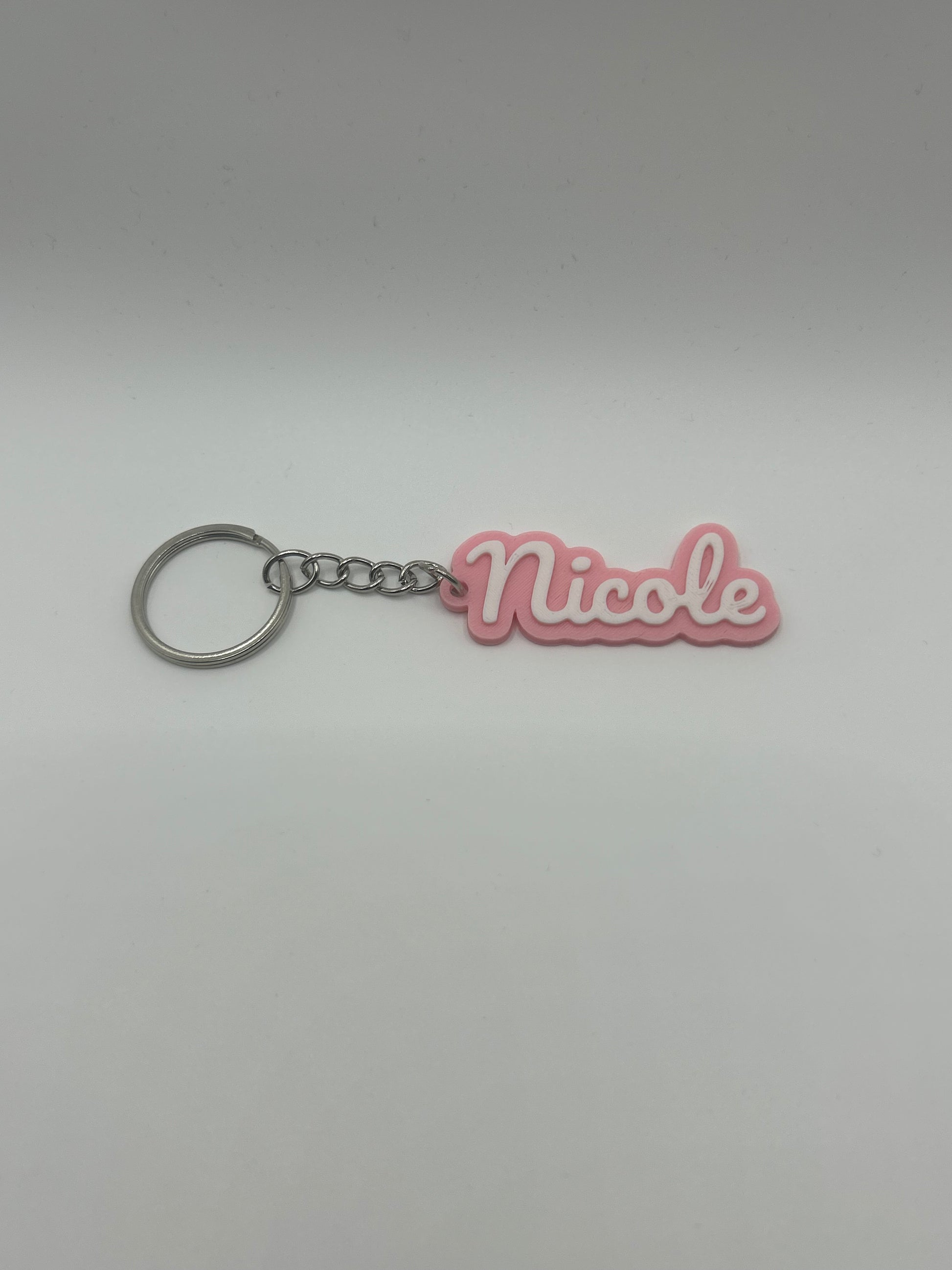 Personalized name keychain from NiccieNacks in various colors, featuring custom text on a stylish keychain accessory.
