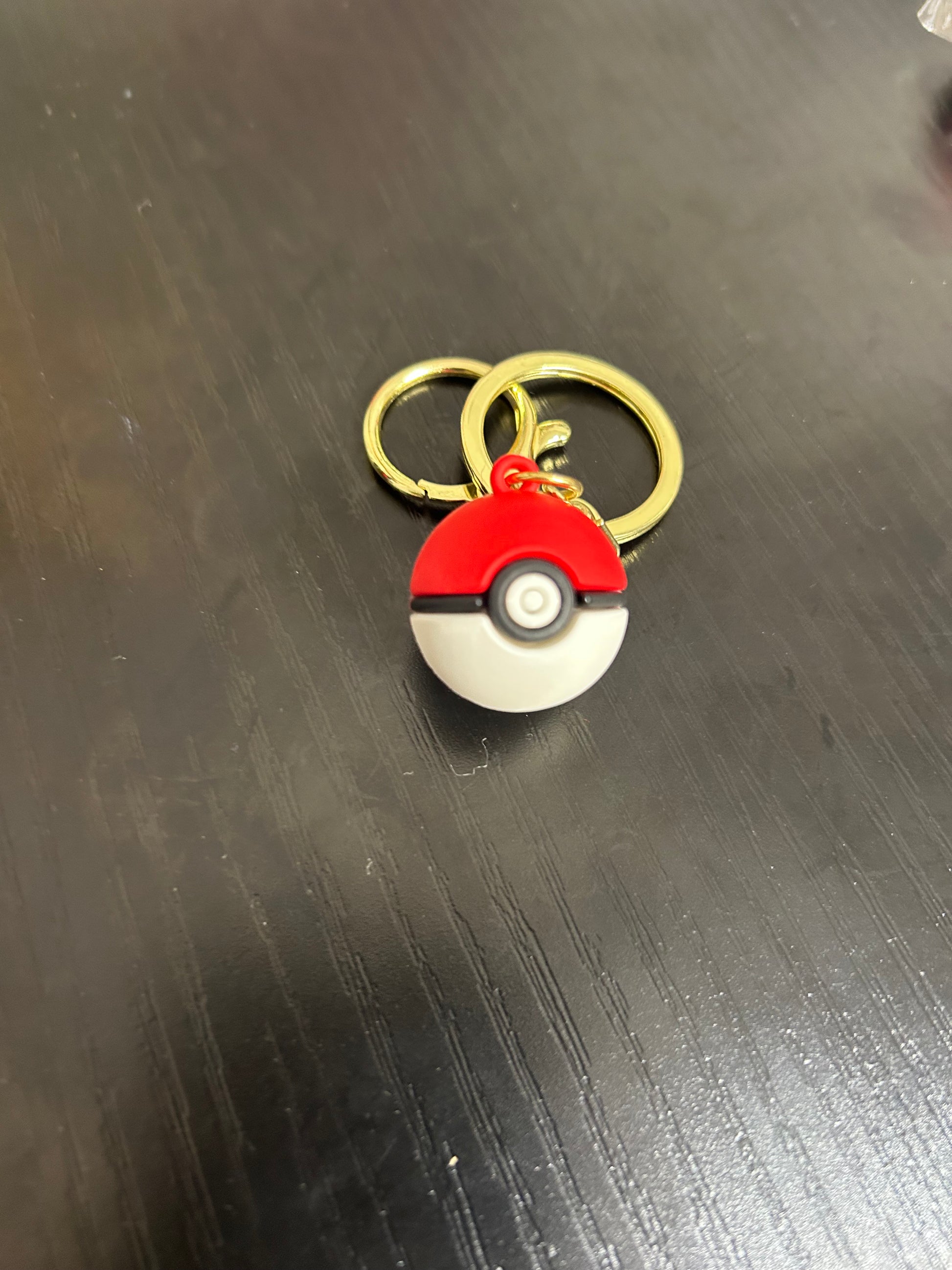 NiccieNacks Pokemon Ball keyring featuring a red and white spherical design with detailed Pokémon branding.
