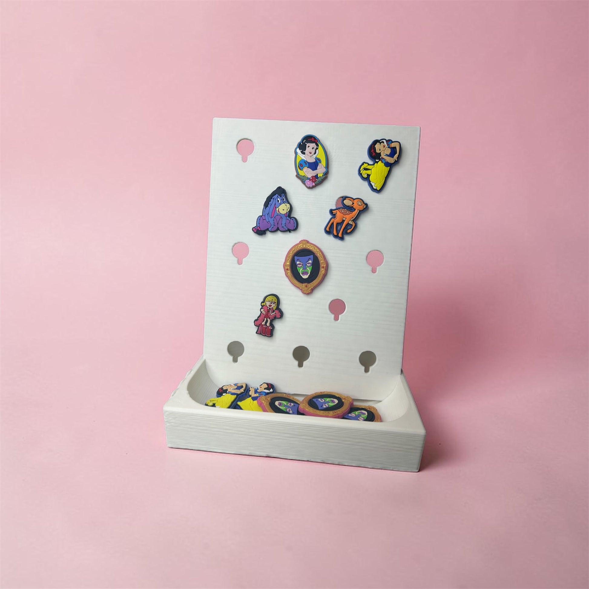 NiccieNacks Croc Jibbitz charm display stand shown with colorful charms on a home decor surface.