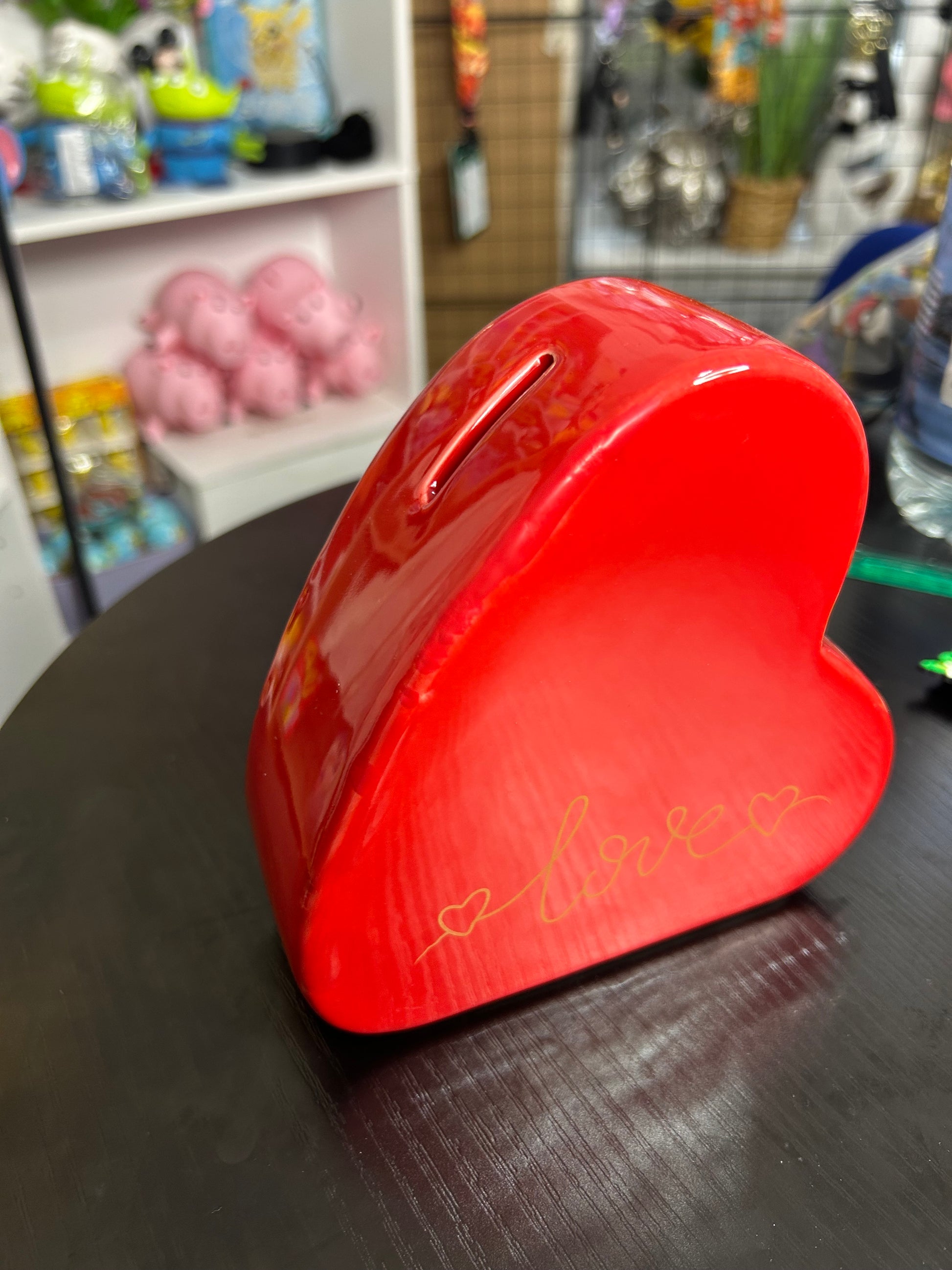 Red ceramic love heart-shaped money box for home decor by NiccieNacks, featuring a glossy finish and coin slot on top.