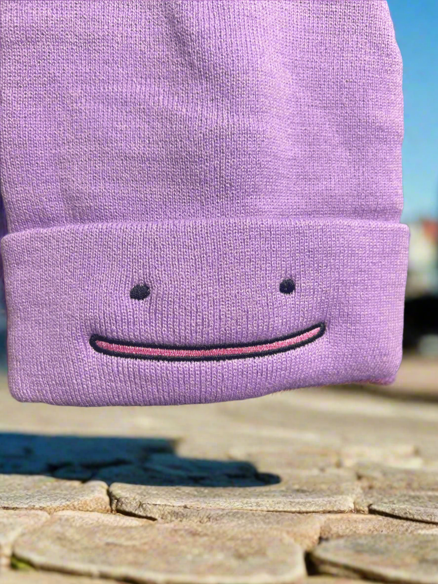 Purple Pokemon Ditto beanie hat by NiccieNacks, featuring a soft knit design with Ditto's face and shape for a cute, playful look.
